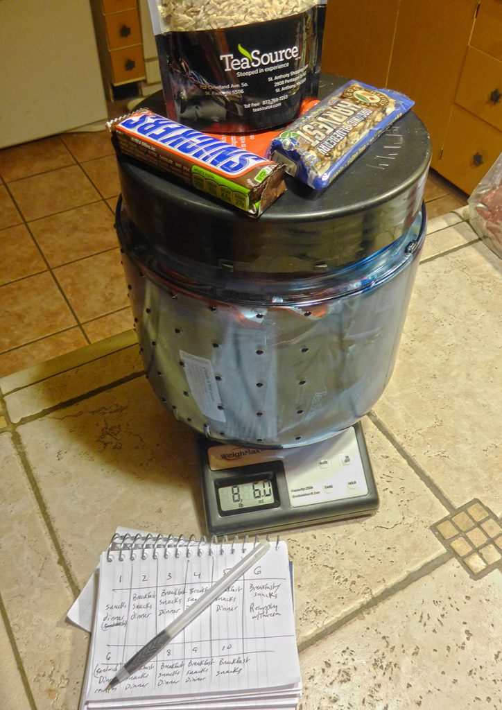 Bear vault filled with food on top of a postal scale