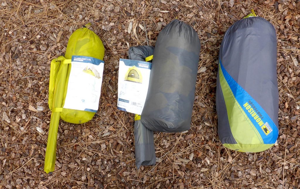 Three different sized backpacking tents packed in their stuff sacks
